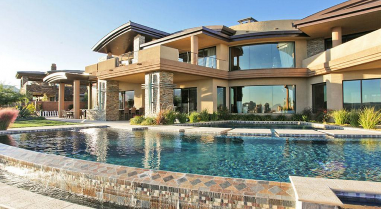 A large two story home with tinted windows overlooks a swimming pool in Ocala, Florida.